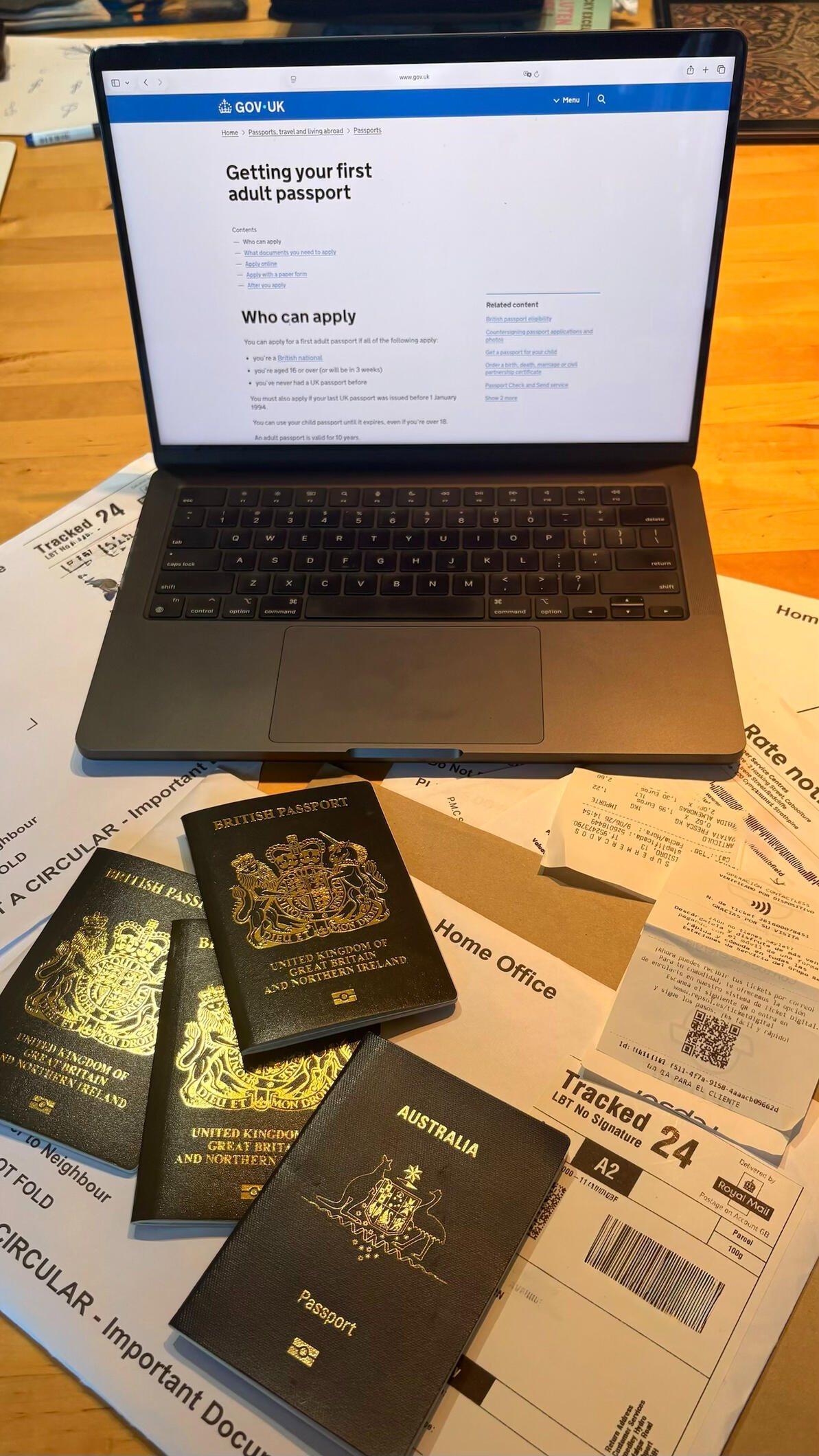 Messy table with laptop, passports and envelopes